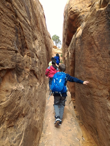 Ascending the short slot canyon behind Navajo Arch, Arches National Park, UT