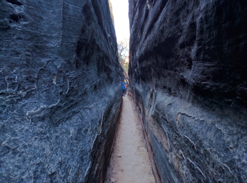 Walking between mushroom rocks which form straight-walled slot canyons, Canyonlands NP, UT